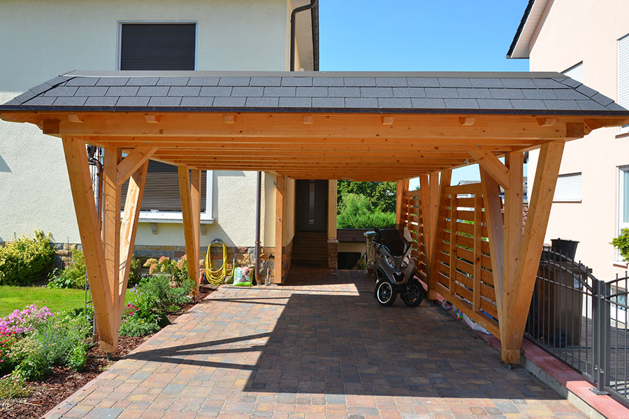 wooden carport with asphalt shingles roof installed at house driveway converse-tx